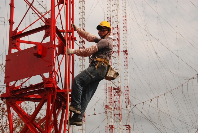 Un ingénieur commence l'ascension des 75m d'une antenne